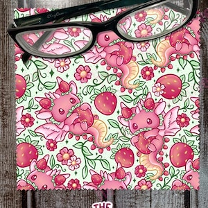 May include: A pink and green microfiber cleaning cloth with a repeating pattern of pink dragons holding strawberries. The dragons have wings and are surrounded by green vines and pink flowers. The text "THE native Creative" is printed in the bottom right corner.