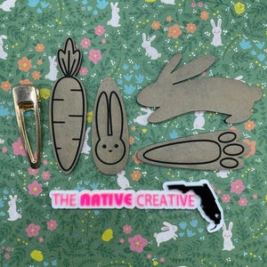May include: A set of four brown wooden cutouts of a carrot, bunny, bunny ears, and bunny footprints. The cutouts are on a green background with a white floral pattern. The text "THE NATIVE CREATIVE" is printed in pink on a white background. A black cutout of the state of Florida is on the right side of the image.