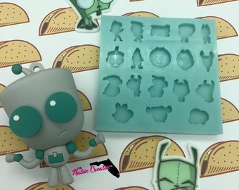 May include: A silicone mold with 16 different shapes of a green cartoon character with large eyes and a small mouth. The character is wearing a grey suit and has a small antenna on its head. There are two finished resin figures of the character, one green and one grey, on a white background with a pattern of brown taco shapes.