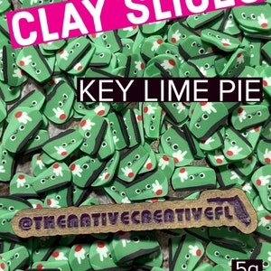 May include: A close-up of a pile of green clay slices with a key lime pie design. The slices have a white and red design. The text "CLAY SLICES" is in a pink rectangle, and "KEY LIME PIE" is in a black rectangle. The text "5g" is in the bottom right corner.