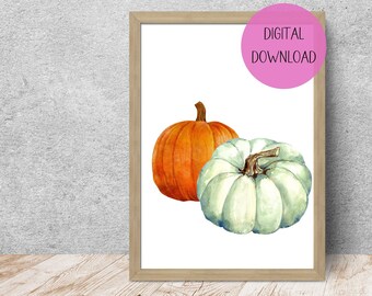 May include: A framed print featuring two watercolor pumpkins. One pumpkin is orange, the other is a pale green. The print has a light wood frame and the text "DIGITAL DOWNLOAD" in a pink circle.