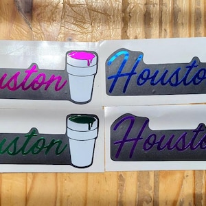 May include: Four stickers featuring the word "Houston" in a stylized script, each with a different colour gradient. Each sticker also has a white cup with coloured liquid spilling over the top.