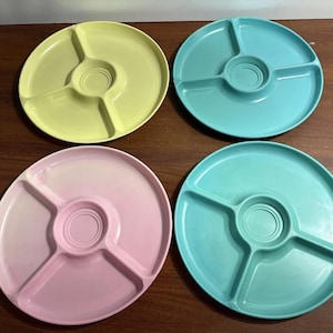 May include: Four colorful divided serving platters in pastel shades of yellow, blue, pink, and teal. Each round platter has three sections and a central dip area, perfect for snacks or appetizers. The platters are made of a durable plastic material.