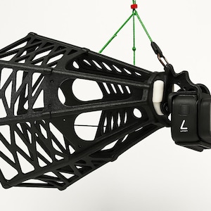 Puede incluir: Jaula de cámara negra con diseño geométrico, suspendida por un cordón verde. La jaula sostiene una cámara de acción negra con el número 7 visible en la parte delantera. La jaula tiene una estructura abierta única.