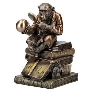 May include: A bronze sculpture of a chimpanzee wearing a jacket and holding a magnifying glass over a skull. The chimpanzee is sitting on a stack of books with the word "Evolution" on one of the books.