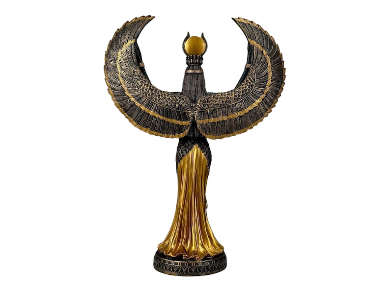 May include: A gold and black statue of the Egyptian goddess Isis with outstretched wings. The statue is standing on a base with intricate details.