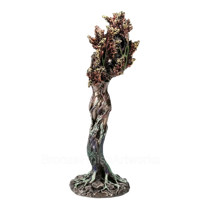 May include: A bronze-toned sculpture depicting a figure merging with a tree, featuring a textured base with exposed roots, a smooth torso, and a crown of detailed, multi-colored foliage in shades of copper, green, and dark brown.
