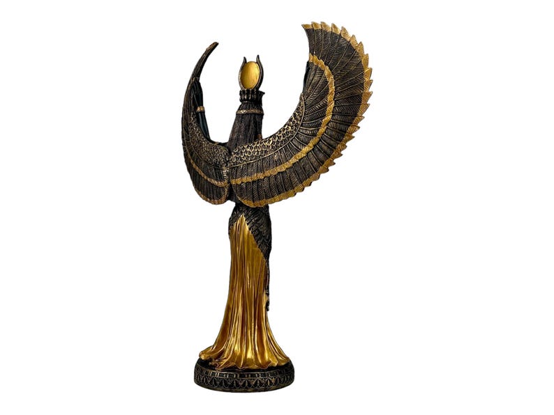 May include: A gold and black statue of the Egyptian goddess Isis with outstretched wings. She is wearing a flowing golden robe and a crown with a sun disk.