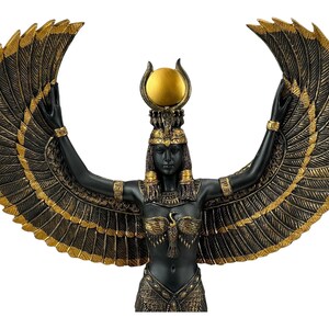 May include: Black and gold statue of the Egyptian goddess Isis with outstretched wings. She wears a crown with a sun disc and holds her arms up in a gesture of protection.