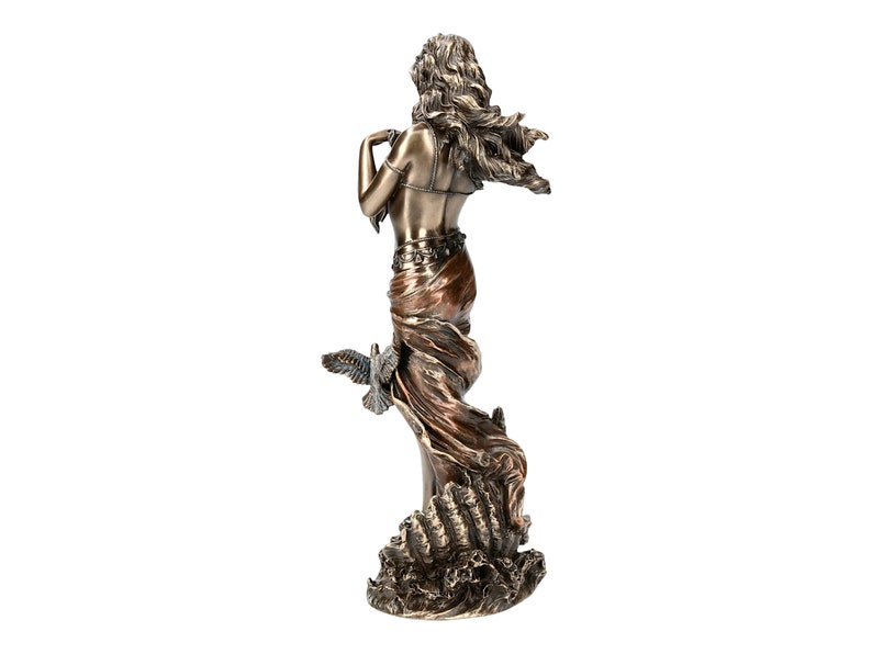 May include: Bronze sculpture of a woman with flowing hair and a flowing robe, standing on a base with waves. She is holding a dove in her hand.