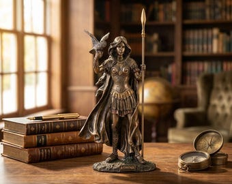 May include: A bronze-toned statue of the goddess Athena standing on a base labeled ATHENA. She wears detailed armor, a flowing cloak, and holds a tall spear in one hand while an owl perches on her other hand. The figure features intricate textures.