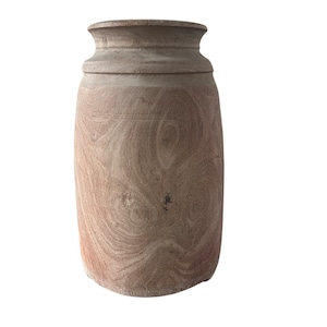 Puede incluir: Un jarrón de madera marrón claro con cuerpo redondeado y parte superior ligeramente acampanada.