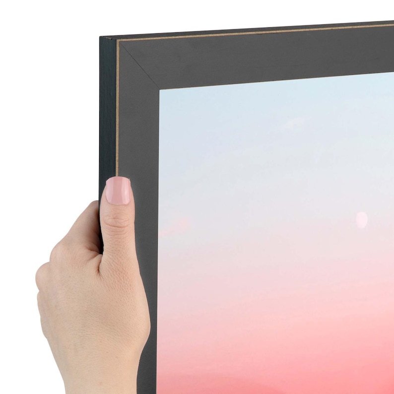 Puede incluir: Un marco de fotos rectangular con acabado negro mate y un borde interior fino en tono dorado. El marco encierra una impresi&oacute;n con un fondo de degradado suave que transiciona de un azul p&aacute;lido en la parte superior a un rosa c&aacute;lido abajo.