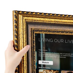 K&ouml;nnte beinhalten: Verzierter goldener Bilderrahmen mit dunkelbraunem Innenrand. Der Rahmen umgibt einen Bildschirm mit den Worten "LIVING OUR LIVE" und der Beschreibung eines Familiendramas. Der Rahmen wird von einer Hand gehalten.