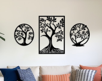 May include: Three black metal wall decor pieces in the shape of trees. The center piece is a rectangular tree with a thick trunk and branches with leaves. The two side pieces are round trees with thinner trunks and branches with leaves. The wall decor is hanging on a white wall above a white couch with pillows.