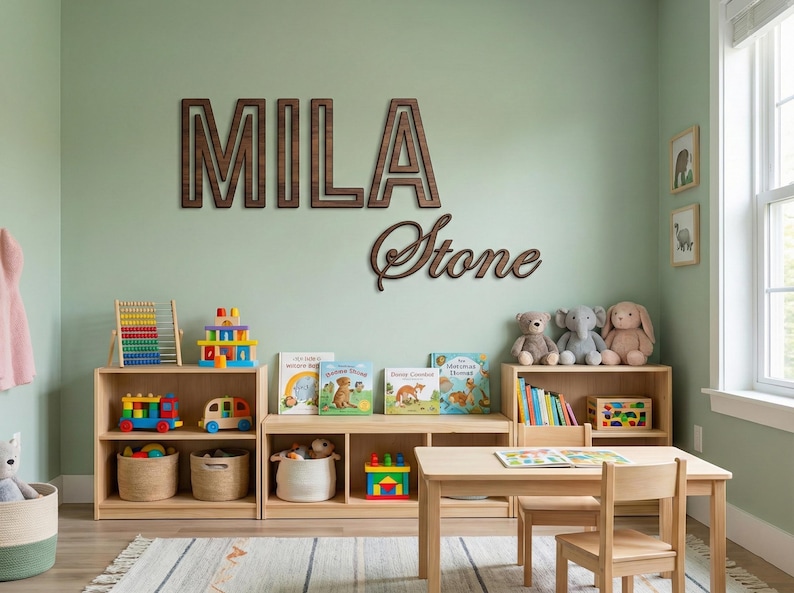 Puede incluir: Una sala de juegos para ni&ntilde;os con estanter&iacute;as de madera, juguetes y libros. El nombre "MILA Stone" se muestra en la pared con letras de madera. La habitaci&oacute;n cuenta con una mesa, sillas y una alfombra.