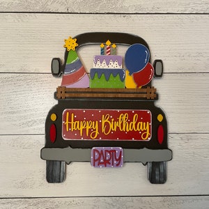 May include: A black pickup truck with a red and white sign that says "Happy Birthday" and a purple sign that says "Party". The truck is decorated with a birthday cake, balloons, and party hats.