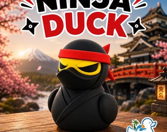 May include: A black rubber duck figurine dressed as a ninja with a red headband and yellow eyes. The text NINJA DUCK appears above the figure. A small logo in the corner reads Salty T's 3D Printing. The duck is on a wooden surface.