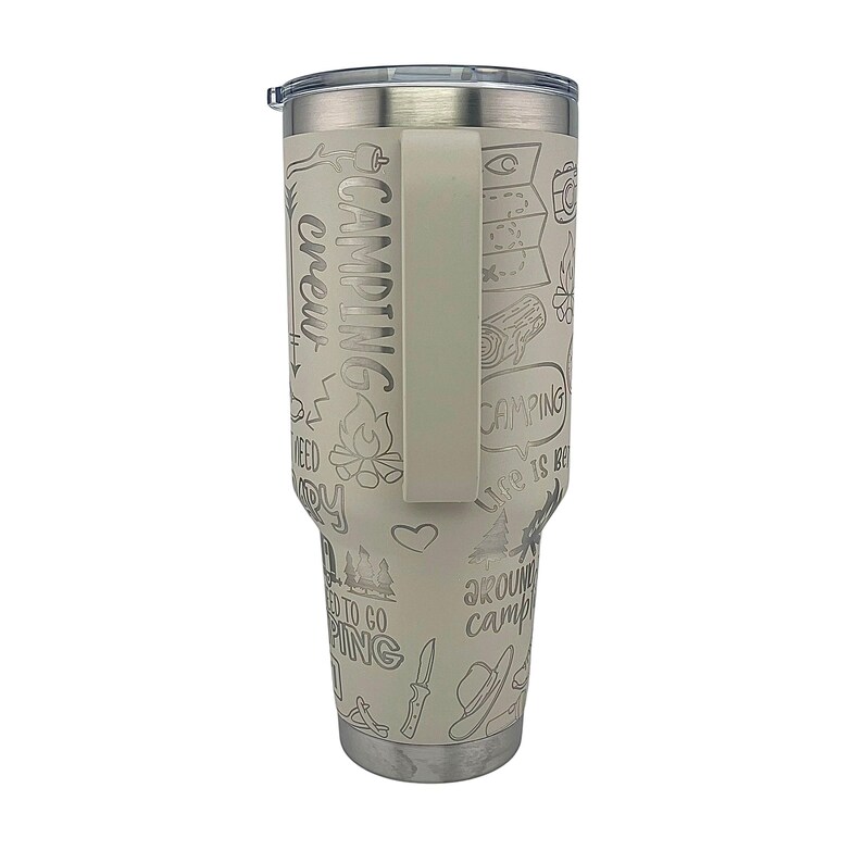 K&ouml;nnte beinhalten: Ein wei&szlig;er Edelstahlbecher mit schwarzem Griff. Der Becher ist mit einem Camping-Motiv verziert und zeigt verschiedene Camping-bezogene Illustrationen und Texte, darunter "Camping Crew", "Life is Better Around Campfire" und "Need to Go Camping".