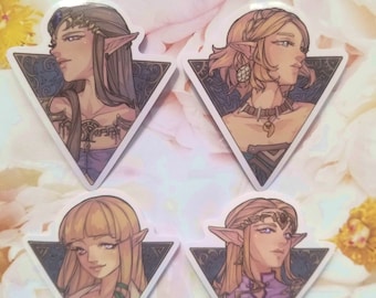 Könnte beinhalten: Vier dreieckige Aufkleber mit Illustrationen von Charakteren aus der Videospielserie The Legend of Zelda. Jeder Aufkleber zeigt einen anderen Charakter mit einem einzigartigen Design und Farbschema.