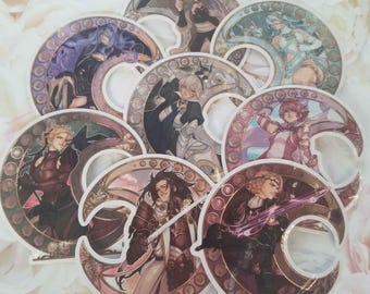 May include: Set of eight colorful round stickers featuring different characters with intricate designs. Each sticker has a crescent moon shape with a circular pattern around it. The characters are depicted in various poses and outfits.