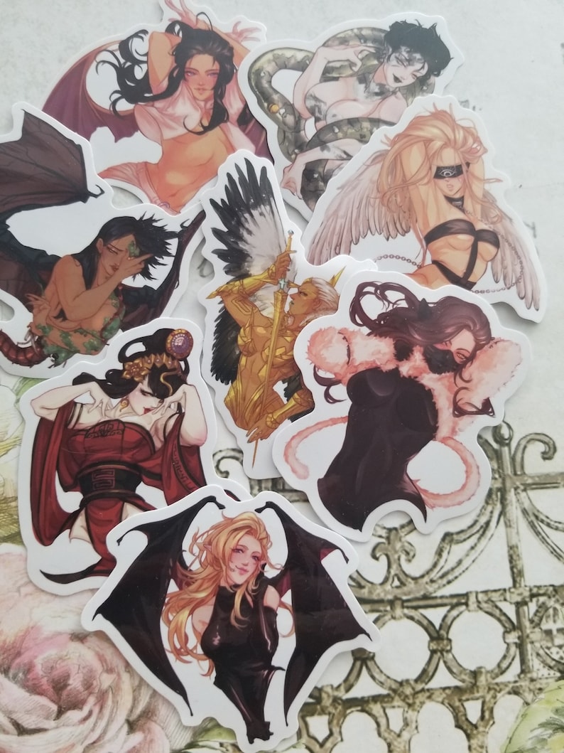 May include: Set of eight stickers featuring women with different wings and costumes. The stickers are printed on white paper and have a glossy finish. The women are depicted in various poses, including flying, standing, and sitting. The wings are a variety of colors, including black, white, and gold. The costumes are also a variety of colors, including red, black, and white.