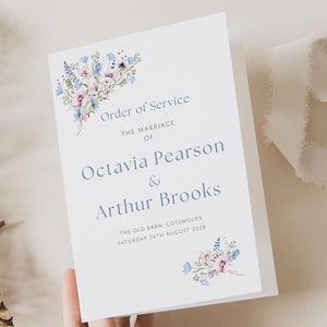 May include: A white wedding ceremony order of service card with blue and pink watercolour floral illustrations. The text reads "Order of Service", "The Marriage of", "Octavia Pearson & Arthur Brooks", "The Old Barn, Cotswolds", "Saturday 24th August 2028".