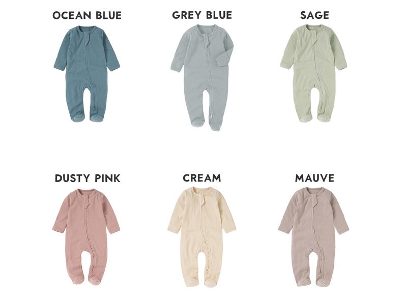 May include: A collection of six baby footed pajamas in various colors: ocean blue, grey blue, sage, dusty pink, cream, and mauve. Each one-piece garment has long sleeves and a button-up front. The names of the colors are displayed above each pajama.