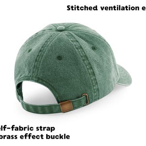 May include: A green baseball cap with stitched ventilation eyelets and a self-fabric strap with a brass effect buckle. The cap has a curved brim and a button on top. The text "Stitched ventilation eyelets" and "Self-fabric strap with brass effect buckle" are visible.