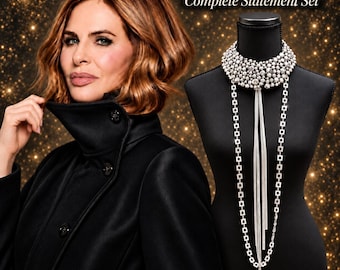 Op de afbeelding: Een 3 Necklace Bundle Complete Statement Set gepresenteerd op een zwarte etalagepop. De set bevat een brede, meerlaagse kralen choker, een lange ketting met vierkante schakels en een centraal hangertje met lange, dunne zilverkleurige draden.