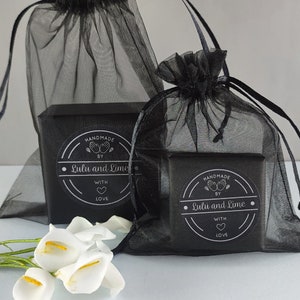May include: Two black gift boxes with black and silver labels that say "Handmade by Lulu and Lime with love" are wrapped in black tulle bags.