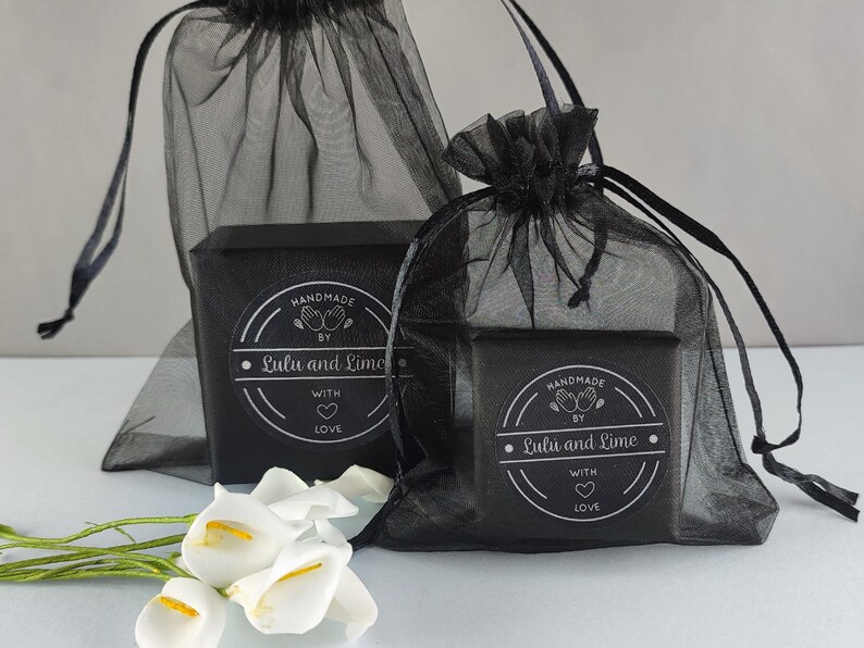 May include: Two black gift boxes with black and silver labels that say "Handmade by Lulu and Lime with love" are wrapped in black tulle bags.