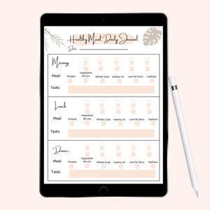 May include: A black tablet displays a "Healthy Meal Daily Journal" layout with sections for morning, lunch, and dinner. Each section includes meal categories like protein, vegetables, and seafood. A white stylus rests on the right side.