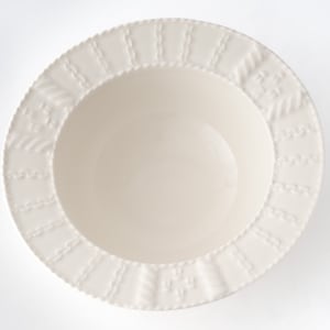 Puede incluir: Tazón de cerámica blanco con un patrón decorativo en relieve alrededor del borde.