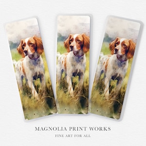 May include: Three watercolor bookmarks featuring a brown and white Brittany dog standing in a field of green grass. The bookmarks are printed on a white background with the text "Magnolia Print Works Fine Art For All" at the bottom.