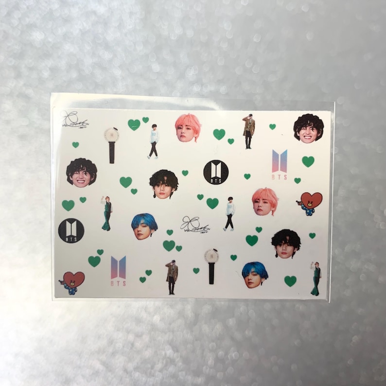 May include: A clear plastic sleeve containing a sheet of stickers. The stickers feature images of people, hearts, logos, and text. The images are in various colors, including pink, blue, and green.