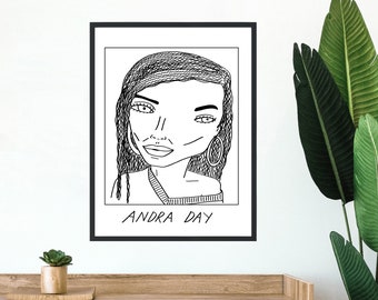 May include: A black and white line drawing of Andra Day, a singer, in a framed print. The print has a white background and the text "ANDRA DAY" is written below the drawing.