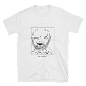 Pode incluir: Camiseta branca com um desenho a traço preto de um homem sorrindo com barba dentro de um quadro retangular. O nome "MICHAEL" é impresso em preto abaixo.