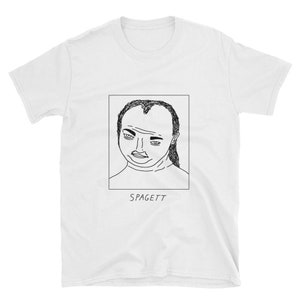 May include: White t-shirt featuring a black and white line drawing of a person's face inside a rectangle. The word "SPAGETT" is printed in black below the drawing. The t-shirt has short sleeves and a crew neck.