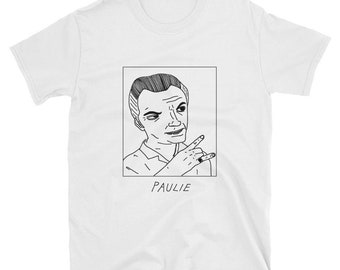 May include: A white t-shirt with a black and white line drawing of a man's face with the word "PAULIE" underneath.