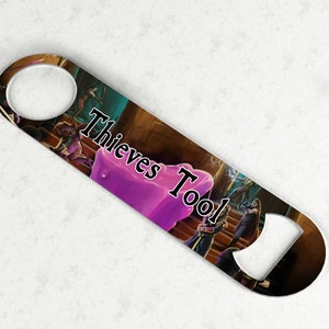 May include: A silver bottle opener with a colorful fantasy illustration featuring a purple orb and the text "Thieves Tool".