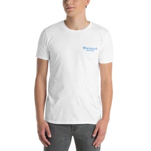 Könnte beinhalten: Weißes T-Shirt mit kurzen Ärmeln und dem blauen Text "WIKIPEDIA EDITOR" auf der Brust. Das T-Shirt ist aus einem weichen Material.
