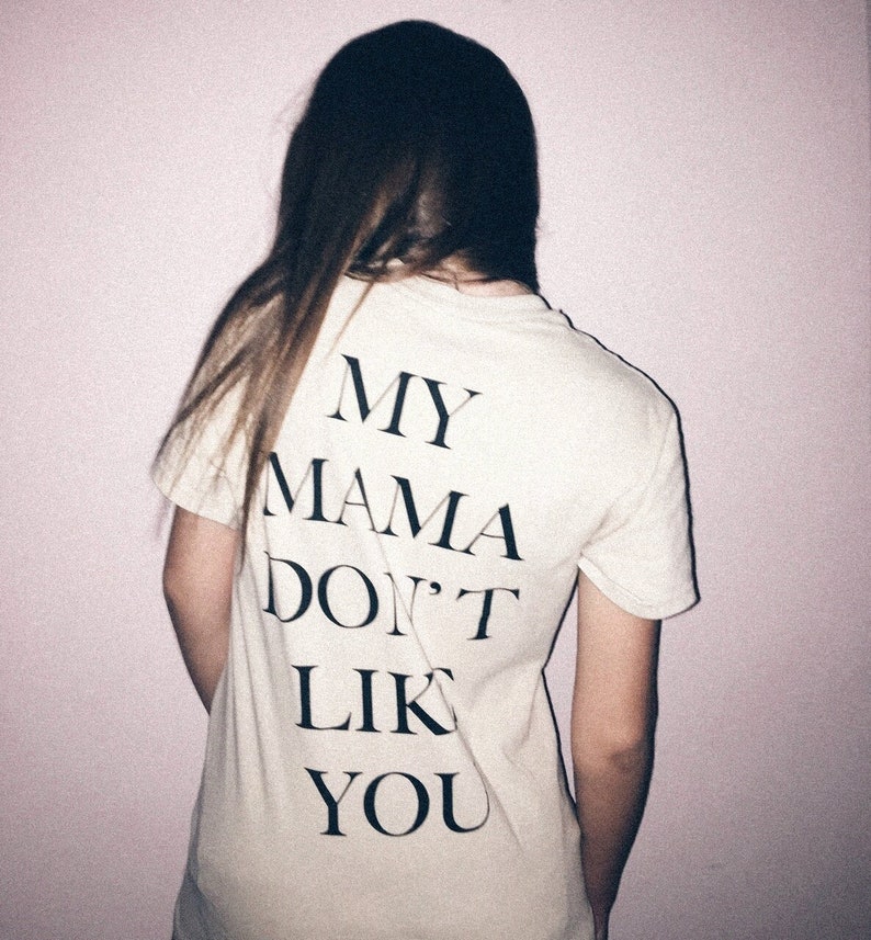 May include: A white t-shirt with black text that reads "MY MAMA DON'T LIKE YOU".