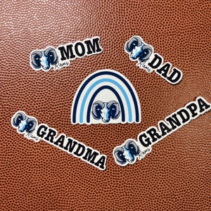 May include: A set of six Rams-themed stickers with a rainbow design, featuring the words "Mom", "Dad", "Grandma", "Grandpa", and "Rams".