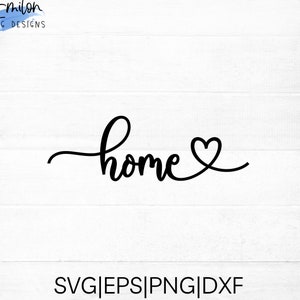 Puede incluir: Texto en cursiva en blanco y negro que dice "home" con un pequeño corazón al final. El texto está sobre un fondo de madera blanca.