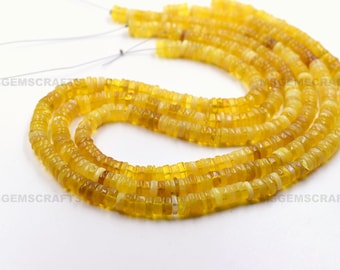 May include: A strand of yellow opal beads, each bead is a small, square shape. The beads are strung on a thin wire and are arranged in a loose, flowing pattern.
