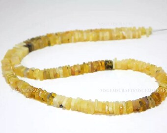 May include: A strand of yellow opal beads, each bead is a rectangular shape. The beads are strung on a clear thread.