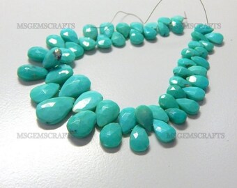 May include: A strand of turquoise gemstone beads in a teardrop shape. The beads are a bright, vibrant turquoise colour and are strung on a thin wire.