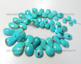 May include: A strand of turquoise gemstone beads in a teardrop shape. The beads are a vibrant blue-green colour with brown and black inclusions. The beads are strung on a thin wire.