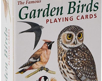 Puede incluir: Una baraja de cartas de juego con una variedad de pájaros, incluyendo un búho, un jilguero, un ampelis y un vencejo. La caja es blanca con texto verde que dice "The Famous Garden Birds Playing Cards". La caja también presenta el logotipo de Heritage Playing Card Company.